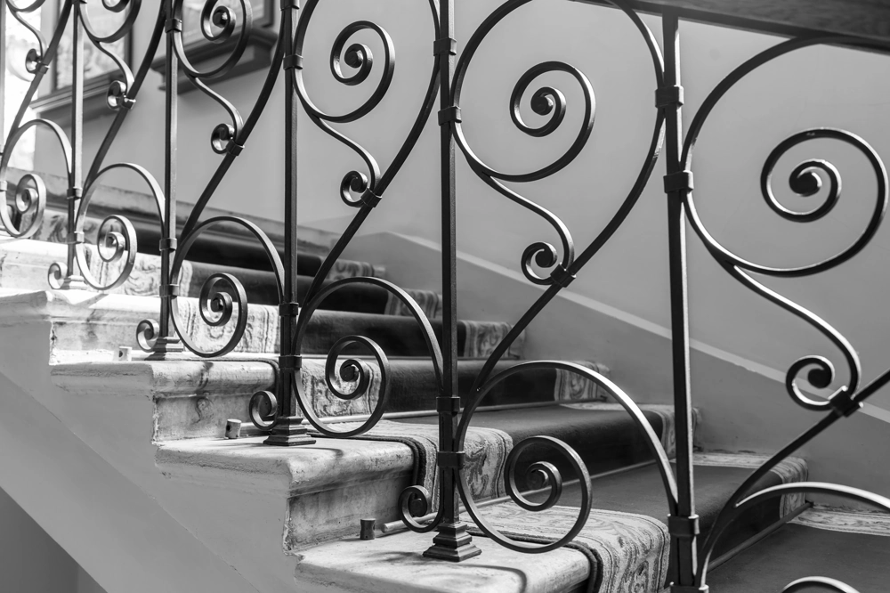 Schody wewnętrzne z kutą balustradą metalową