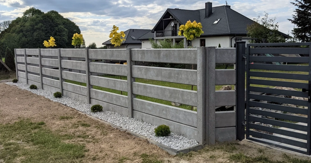 Ogrodzenia betonowe z poziomymi przęsłami i metalową bramą wejściową
