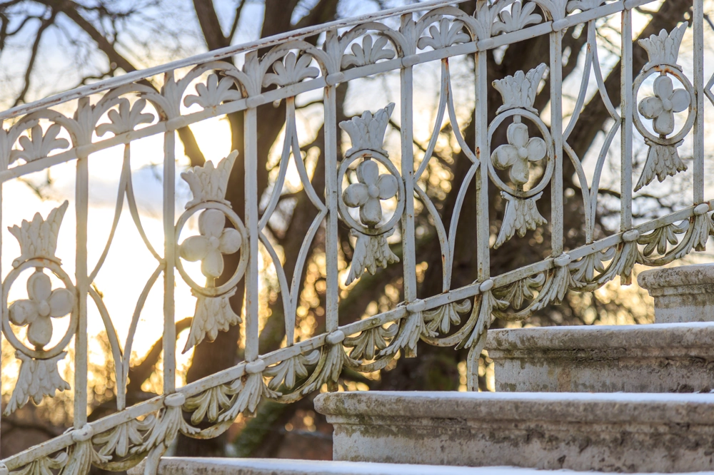 Balustrady kute biała metalowa balustrada ze zdobieniami na zewnętrznych schodach